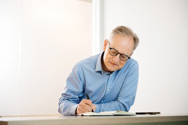 man writing at a desk