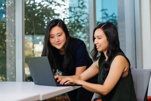Two women sat at a computer